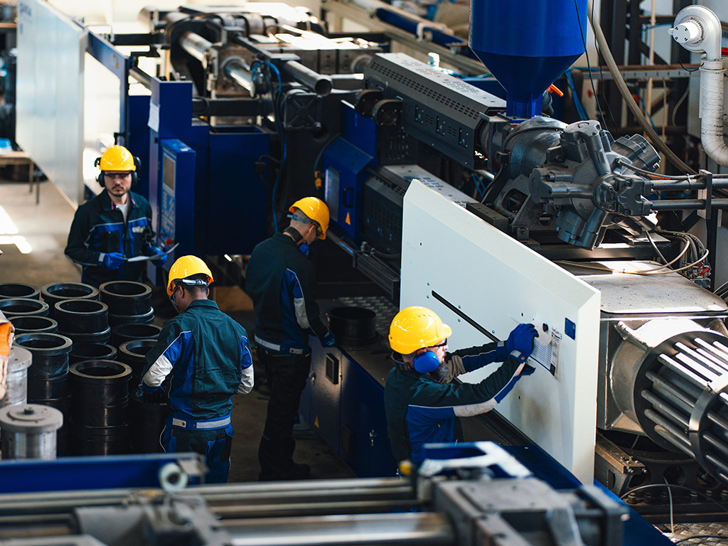 Industrial Workers Operating Machinery in a Busy Factory